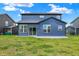 A modern home's backyard featuring a patio and blue siding, providing a serene outdoor space for relaxation and entertainment at 5461 Oak Knoll Dr, Whitestown, IN 46075