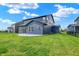 A well-maintained backyard featuring a blue house, patio, and greenery, perfect for outdoor activities and relaxation at 5461 Oak Knoll Dr, Whitestown, IN 46075
