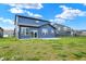 A spacious backyard featuring a concrete patio, lush lawn, and a modern two-story home with blue siding at 5461 Oak Knoll Dr, Whitestown, IN 46075