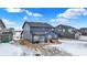 Blue two-story home featuring a patio, covered in snow, simple backyard under a bright sky in a new home community in winter at 5461 Oak Knoll Dr, Whitestown, IN 46075