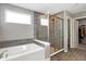 Bathroom featuring a bathtub, a glass enclosed shower and a view to the walk-in closet at 5461 Oak Knoll Dr, Whitestown, IN 46075
