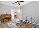 Well-lit bedroom with a piano, bright rug, a ceiling fan, and a doorway to another room at 5461 Oak Knoll Dr, Whitestown, IN 46075