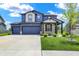 Beautiful two-story home featuring a three car garage, manicured lawn, and attractive blue and gray exterior at 5461 Oak Knoll Dr, Whitestown, IN 46075