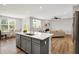 Spacious kitchen island with quartz countertops, stainless steel sink, and open view to the dining and living room area at 5461 Oak Knoll Dr, Whitestown, IN 46075