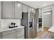Bright kitchen featuring gray cabinets, subway tile backsplash, stainless steel refrigerator, and modern built-in appliances at 5461 Oak Knoll Dr, Whitestown, IN 46075
