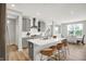Open-concept kitchen with a large island, white countertops, gray cabinets, and modern pendant lighting over a dining area at 5461 Oak Knoll Dr, Whitestown, IN 46075