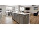 Bright kitchen island with stainless appliances and hardwood floors open to living and dining area at 5461 Oak Knoll Dr, Whitestown, IN 46075