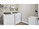 Efficient laundry room featuring modern washer and dryer units and convenient shelving at 5461 Oak Knoll Dr, Whitestown, IN 46075