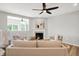 Comfortable living room with fireplace, neutral decor, wood floors, ceiling fan, and ample natural light at 5461 Oak Knoll Dr, Whitestown, IN 46075