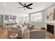 Open-concept living room featuring wood floors, modern furniture, a cozy fireplace, and a view of the kitchen at 5461 Oak Knoll Dr, Whitestown, IN 46075