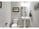 Stylish powder room with a pedestal sink, framed artwork, and modern fixtures at 5461 Oak Knoll Dr, Whitestown, IN 46075