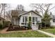 Quaint home with beautiful landscaping, cozy front porch, and a bright green front door at 5626 Winthrop Ave, Indianapolis, IN 46220