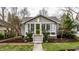 Charming gray craftsman home featuring a green door, gabled roof, and beautifully landscaped front yard at 5626 Winthrop Ave, Indianapolis, IN 46220