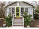 Cozy front porch with vibrant green door and meticulous landscaping offering great curb appeal at 5626 Winthrop Ave, Indianapolis, IN 46220