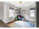 Inviting sitting area with comfy chair, hardwood floors, and natural light at 5626 Winthrop Ave, Indianapolis, IN 46220