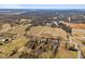 Expansive aerial view of the property, highlighting its location amidst fields, trees, and distant homes at 6724 E Spring Lake Rd, Mooresville, IN 46158