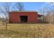 Rustic red barn with weathered exterior in a large grassy field against a blue sky at 6724 E Spring Lake Rd, Mooresville, IN 46158