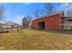 Weathered red barn with a sliding door in a grassy field with clear blue skies at 6724 E Spring Lake Rd, Mooresville, IN 46158