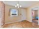 Bright dining area with hardwood floors, brick accent wall, and natural light streaming through the window at 6724 E Spring Lake Rd, Mooresville, IN 46158