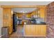 Open kitchen boasts stainless steel appliances and wooden cabinets and an eat-in breakfast bar at 6724 E Spring Lake Rd, Mooresville, IN 46158