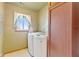 Bright laundry room with modern washer and dryer units and a sunny window at 6724 E Spring Lake Rd, Mooresville, IN 46158