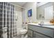 Well-lit bathroom with gray vanity, shower-tub combo, and modern gray striped shower curtain at 7091 Lillian Pl, Cumberland, IN 46229
