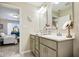 Bright bathroom with a double sink vanity, granite countertops, and a view into the main bedroom at 7091 Lillian Pl, Cumberland, IN 46229