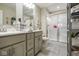 Well-lit bathroom featuring a glass-enclosed shower, gray vanity and practical storage shelves at 7091 Lillian Pl, Cumberland, IN 46229