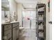 Well-lit bathroom featuring a glass-enclosed shower, gray vanity and practical storage shelves at 7091 Lillian Pl, Cumberland, IN 46229