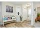 Inviting entryway with bench, closet, wood-look floors and a view of the living area at 7091 Lillian Pl, Cumberland, IN 46229
