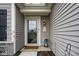 Welcoming front door featuring a decorative welcome sign and a charming outdoor lantern at 7091 Lillian Pl, Cumberland, IN 46229