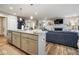 Modern kitchen island with granite countertops and a view into the living room at 7091 Lillian Pl, Cumberland, IN 46229