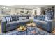 Comfortable living room area with a large blue sectional and modern coffee tables at 7091 Lillian Pl, Cumberland, IN 46229