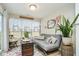 Bright sun room with cozy seating, natural light, and a charming decorative trunk at 7091 Lillian Pl, Cumberland, IN 46229