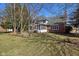 Expansive backyard showcasing a screened porch, lawn and mature trees on a sunny day at 7238 River Birch Ln, Indianapolis, IN 46236