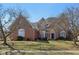 Stately brick home showcasing mature trees, manicured lawn, and charming architectural details at 7238 River Birch Ln, Indianapolis, IN 46236