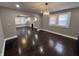 Spacious living room featuring hardwood floors, an elegant light fixture, and an arched doorway to the living area at 749 W 32Nd St, Indianapolis, IN 46208