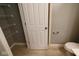 A bathroom with a toilet, wire rack shelving, and a door at 8105 Milender Blvd, Indianapolis, IN 46237