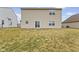 Backyard featuring a grassy lawn and view of the home's back exterior with sliding glass door at 8547 S Tibbs Ave, Indianapolis, IN 46217