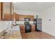 Well-appointed kitchen includes wood cabinets, black appliances and laminate countertop at 8547 S Tibbs Ave, Indianapolis, IN 46217