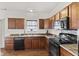 Modern kitchen showcases wood cabinets, black appliances, and ample counter space at 8547 S Tibbs Ave, Indianapolis, IN 46217