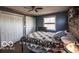 Cozy bedroom with hardwood floors, blue accent wall, ample natural light, and double closets at 9464 N State Rd 135, Morgantown, IN 46160