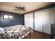 Bedroom featuring hardwood floors, a ceiling fan, blue accent wall, and double closets at 9464 N State Rd 135, Morgantown, IN 46160