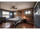 Bedroom featuring hardwood floors, wood paneling, a ceiling fan, and two windows at 9464 N State Rd 135, Morgantown, IN 46160
