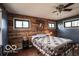 Bedroom featuring hardwood floors, wood paneling, a ceiling fan, and two windows at 9464 N State Rd 135, Morgantown, IN 46160