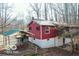 Showcasing the home's exterior, featuring a carport, red siding, and a natural, wooded backdrop at 9464 N State Rd 135, Morgantown, IN 46160