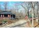 Scenic view of a one-story home with a matching shed on a gravel drive surrounded by trees at 9464 N State Rd 135, Morgantown, IN 46160