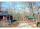 View of the home with a detached outbuilding and carport, all with matching red exteriors and green roofs at 9464 N State Rd 135, Morgantown, IN 46160