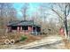 Charming one-story home featuring a long gravel driveway, wooded surroundings, and a covered parking area at 9464 N State Rd 135, Morgantown, IN 46160