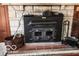 Close-up of stone fireplace with black wood-burning stove and vintage-style accessories for a cozy ambiance at 9464 N State Rd 135, Morgantown, IN 46160